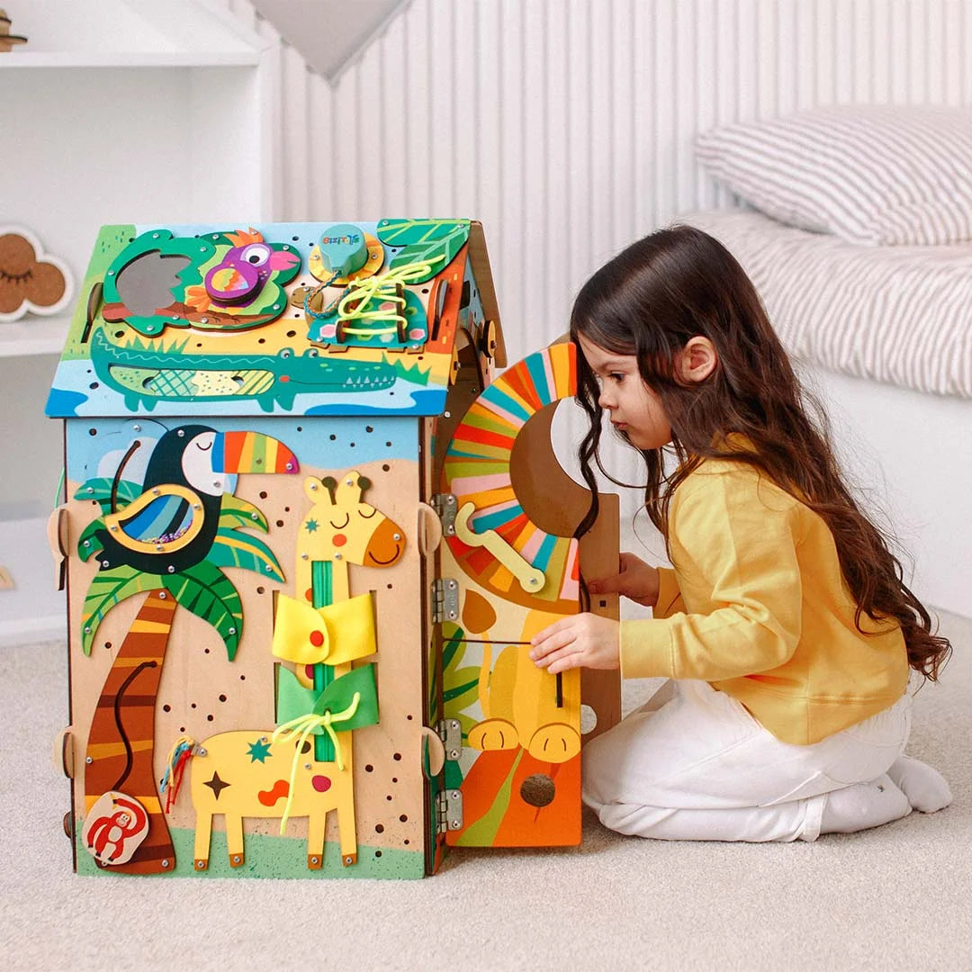 Toddler opening door on Montessori busy board