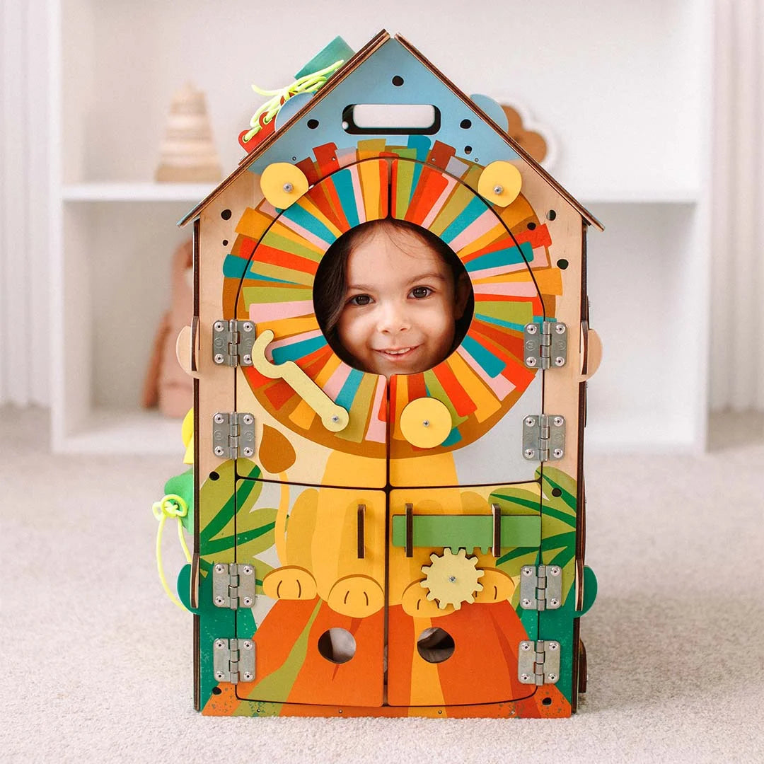Toddler engaged with Montessori busy board jungle playhouse
