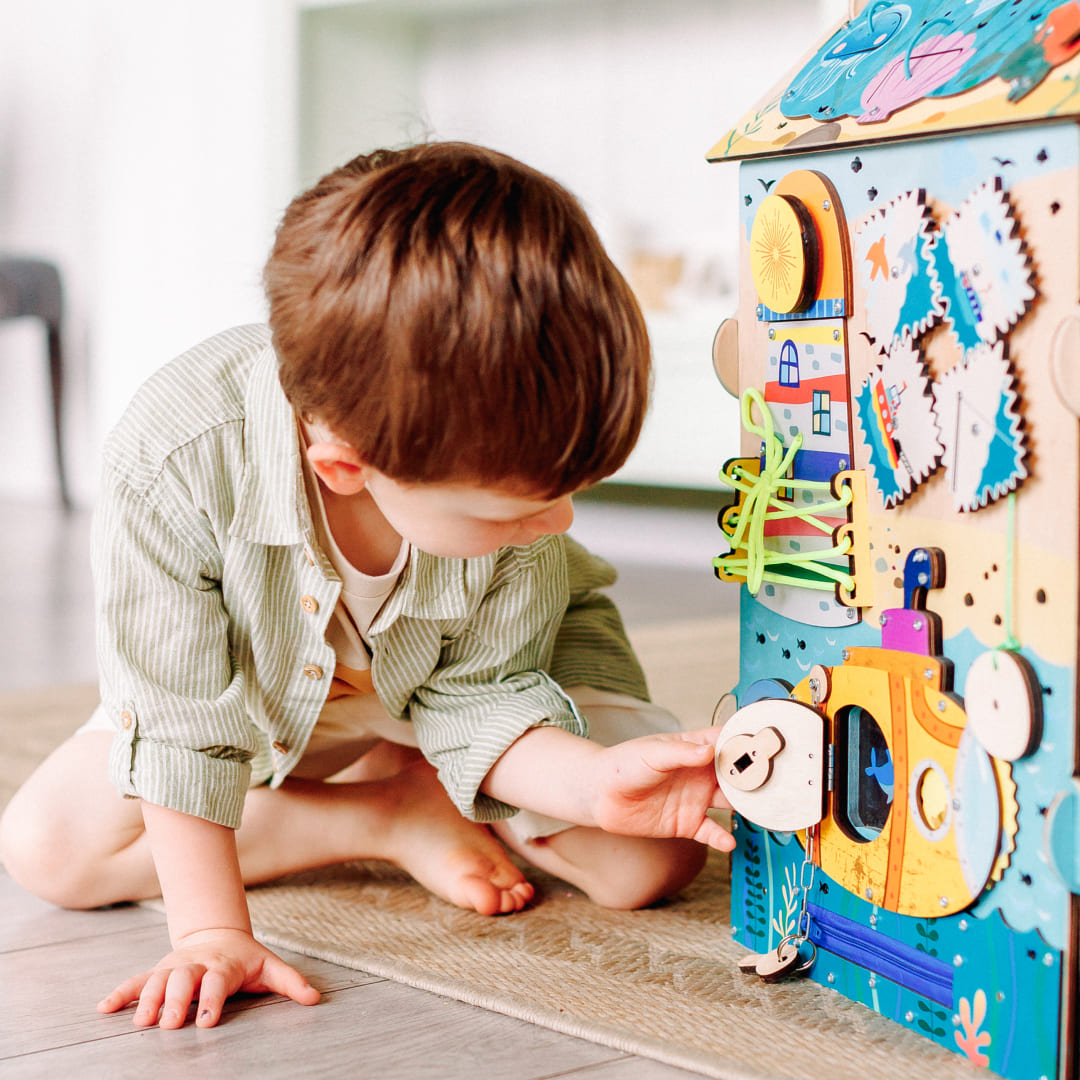 baby playing with montessori pirate busy board
