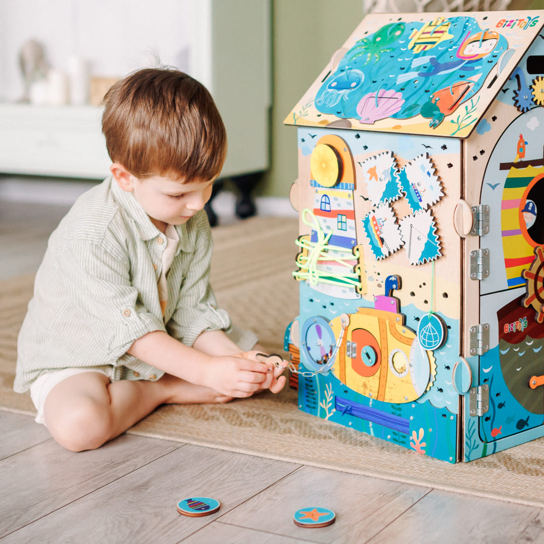 toddler playing with busy board pirate cube